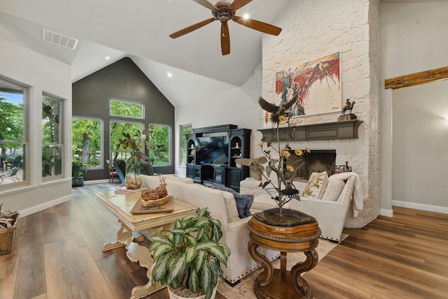 living room featuring baseboards, visible vents, a ceiling fan, wood finished floors, and high vaulted ceiling