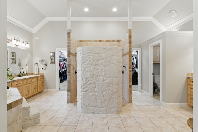 bathroom with lofted ceiling, a spacious closet, vanity, and a walk in shower