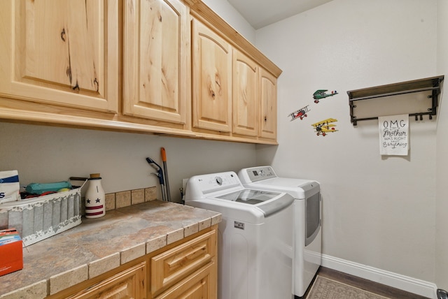 clothes washing area featuring cabinet space, washing machine and dryer, and baseboards