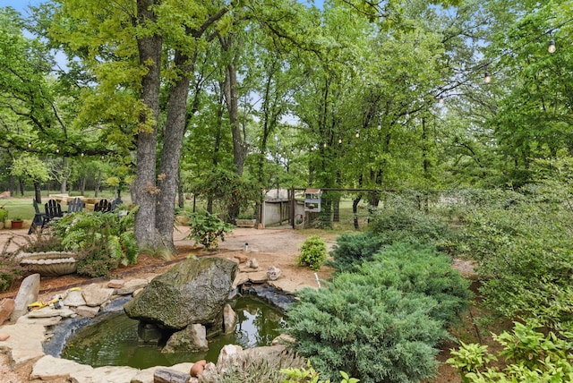 view of yard with fence and a garden pond