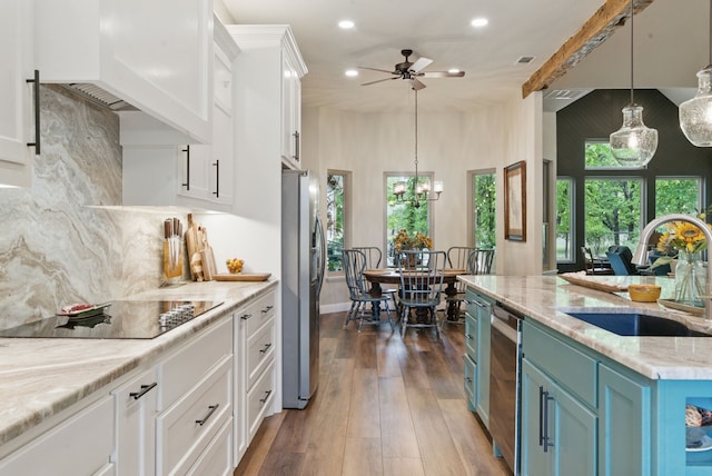 kitchen featuring recessed lighting, a sink, premium range hood, appliances with stainless steel finishes, and white cabinetry