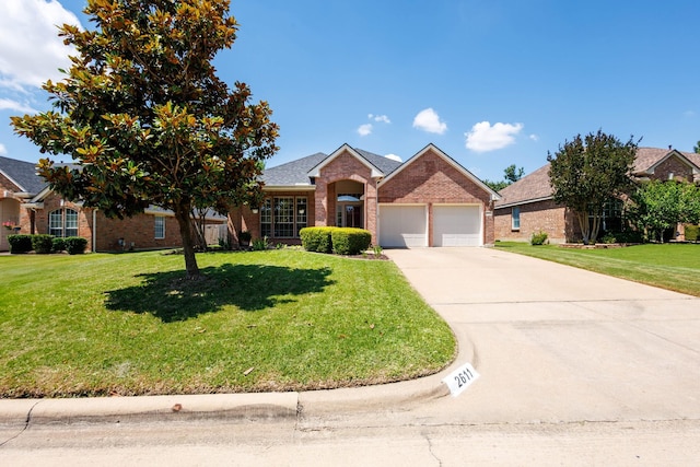 2611 Logan Dr, Mansfield, TX 76063 - view of front facade featuring brick siding, an attached garage, a front yard, and driveway