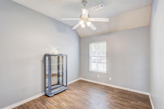 2611 Logan Dr, Mansfield, TX 76063 - empty room with a ceiling fan, wood finished floors, a textured ceiling, vaulted ceiling, and baseboards