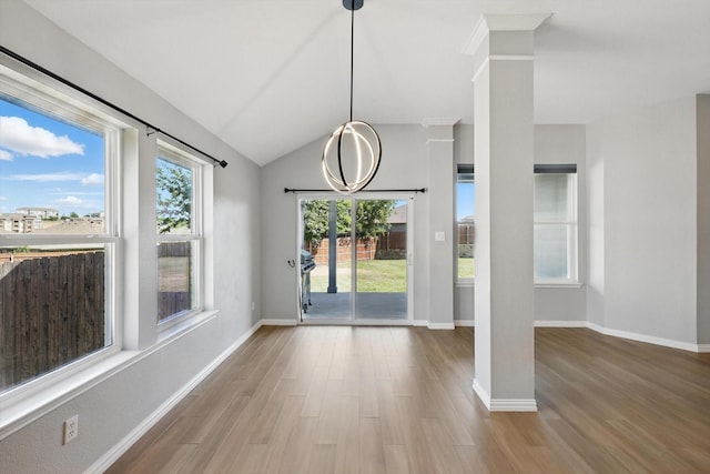 unfurnished dining area with baseboards, lofted ceiling, and wood finished floors