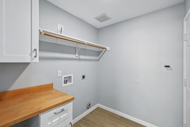 laundry area with hookup for a washing machine, hookup for an electric dryer, light wood-type flooring, baseboards, and visible vents