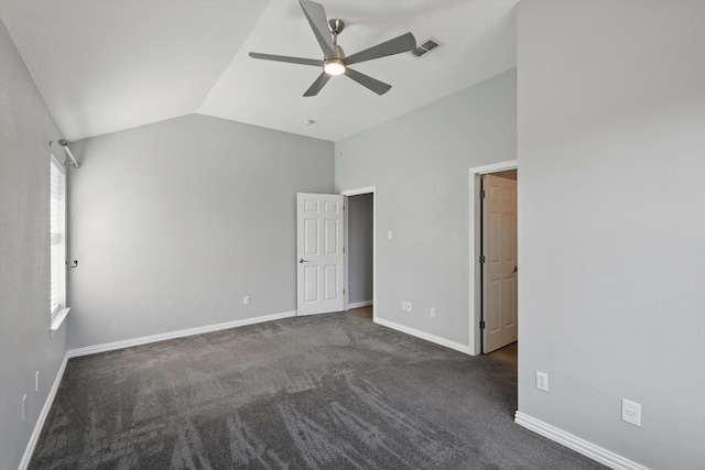 unfurnished bedroom featuring dark carpet, vaulted ceiling, visible vents, and baseboards