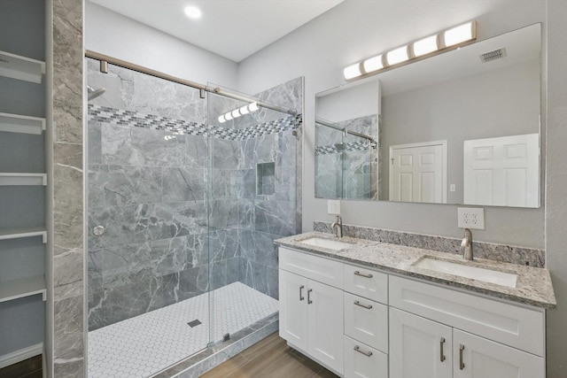 bathroom featuring a sink, double vanity, and a stall shower
