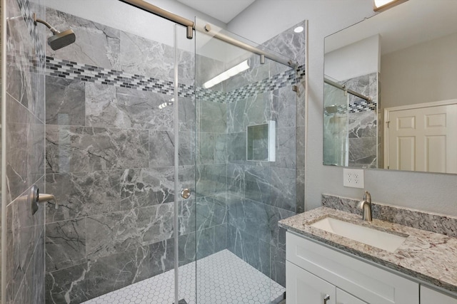 full bath with a shower stall and vanity