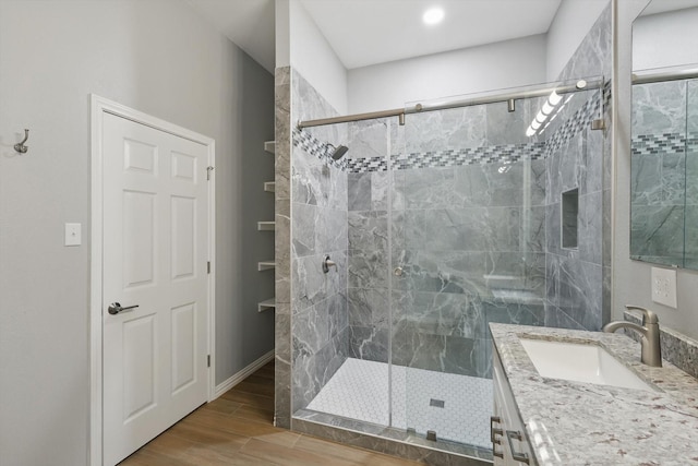 full bath featuring wood finished floors, vanity, and a stall shower