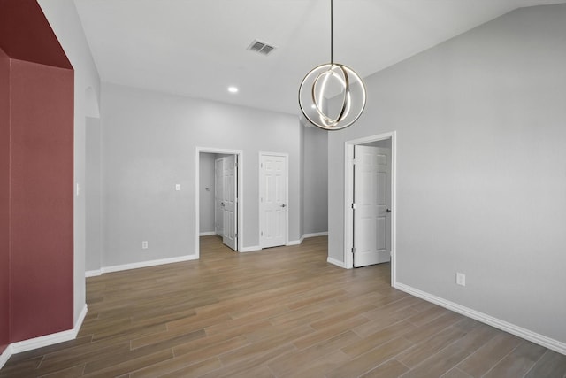 unfurnished dining area with baseboards, visible vents, recessed lighting, a chandelier, and wood finished floors