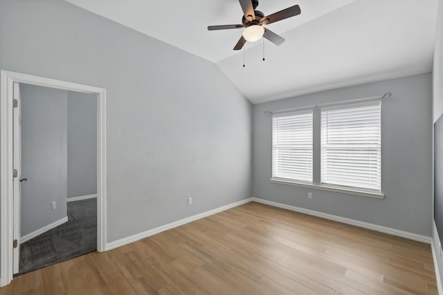 unfurnished bedroom with lofted ceiling, a ceiling fan, wood finished floors, and baseboards