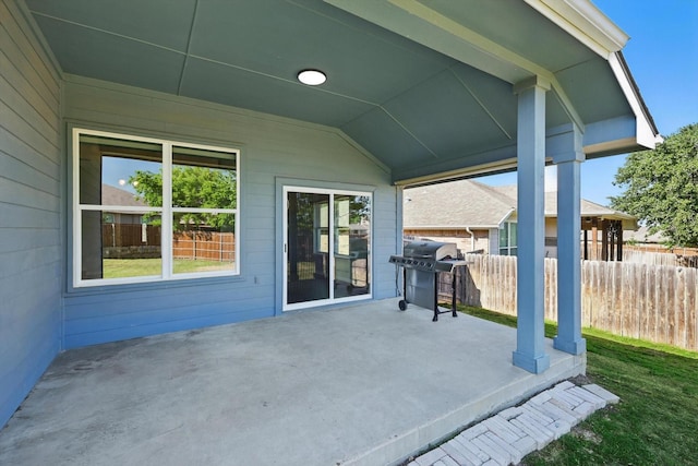 view of patio featuring fence and a grill