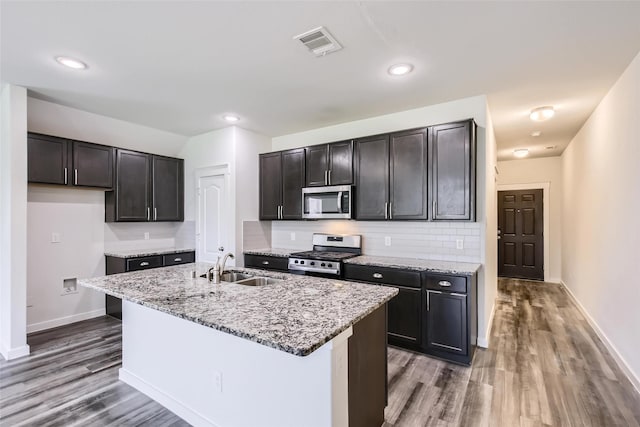 5019 Flanagan Dr, Forney, TX 75126 - kitchen with stainless steel appliances, a sink, wood finished floors, light stone countertops, and baseboards