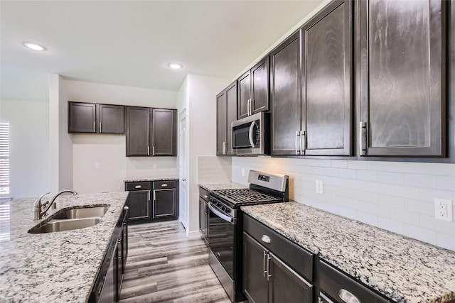 5019 Flanagan Dr, Forney, TX 75126 - kitchen with stainless steel appliances, a sink, light stone counters, light wood-style flooring, and backsplash
