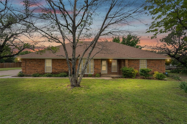 ranch-style home with fence, a yard, and brick siding