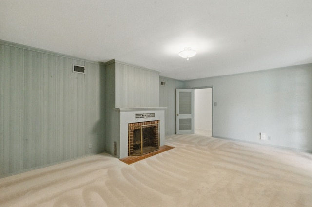unfurnished living room featuring a fireplace, visible vents, and carpet