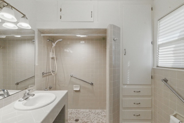 bathroom featuring tile walls, a sink, and tiled shower
