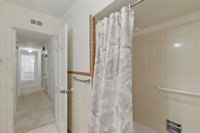 bathroom featuring tile walls and visible vents