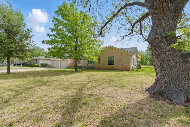 exterior space with a front lawn, brick siding, and a garage