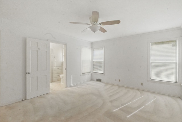 unfurnished bedroom with visible vents, carpet flooring, ornamental molding, and connected bathroom