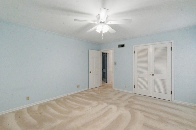 unfurnished bedroom with baseboards, light carpet, visible vents, and a closet