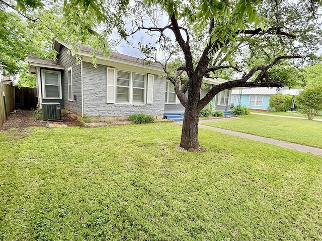 407 W Westhill Dr, Cleburne, TX 76033 - view of front of property with fence, central AC unit, a front yard, and stone siding