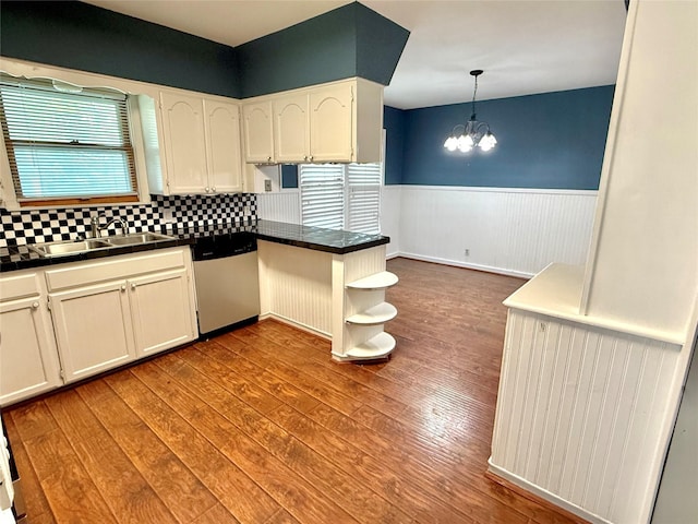407 W Westhill Dr, Cleburne, TX 76033 - kitchen featuring stainless steel dishwasher, a sink, a chandelier, a wainscoted wall, and dark wood-style flooring