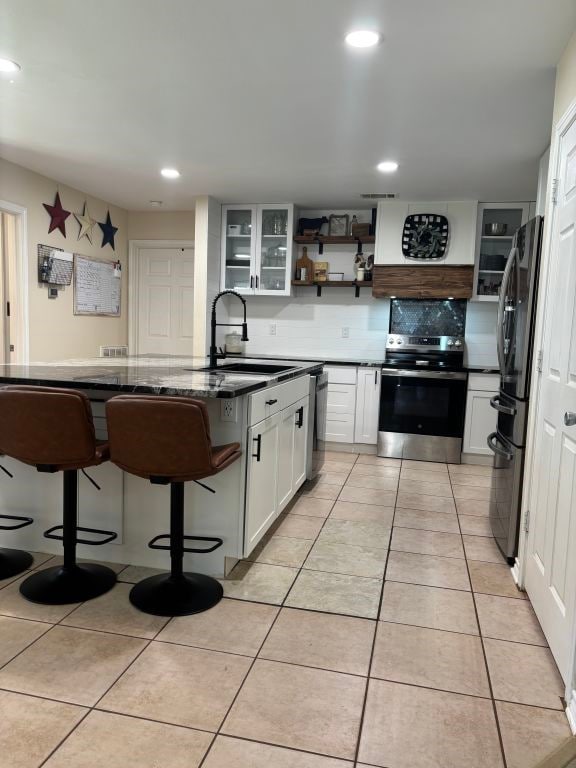 450 Vz County Road 4814, Ben Wheeler, TX 75754 - kitchen with open shelves, a sink, a breakfast bar, white cabinets, and appliances with stainless steel finishes