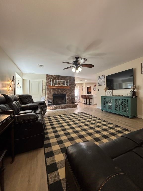 450 Vz County Road 4814, Ben Wheeler, TX 75754 - living area with ceiling fan, a stone fireplace, wood finished floors, and visible vents