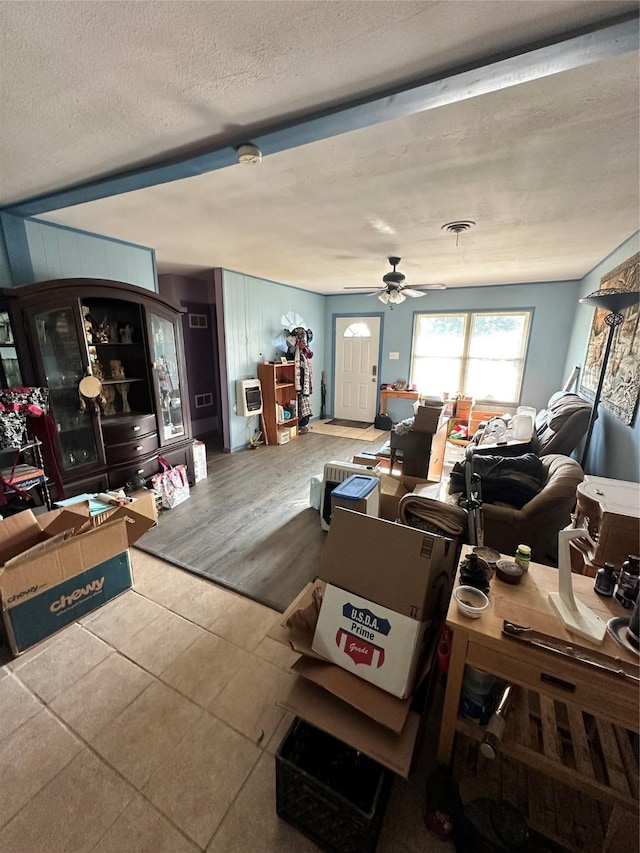 living room featuring a textured ceiling, a ceiling fan, and tile patterned floors