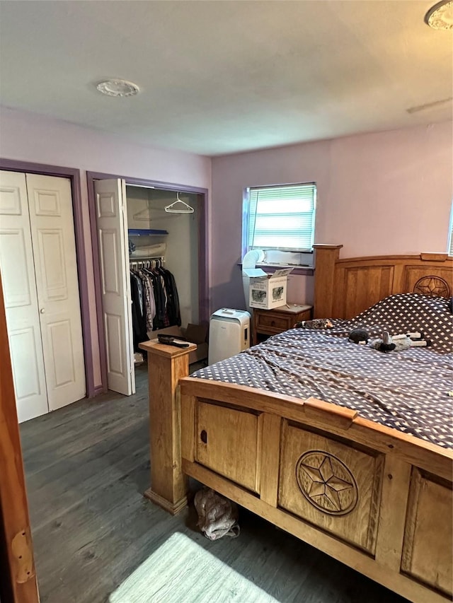 bedroom with two closets and dark wood-type flooring