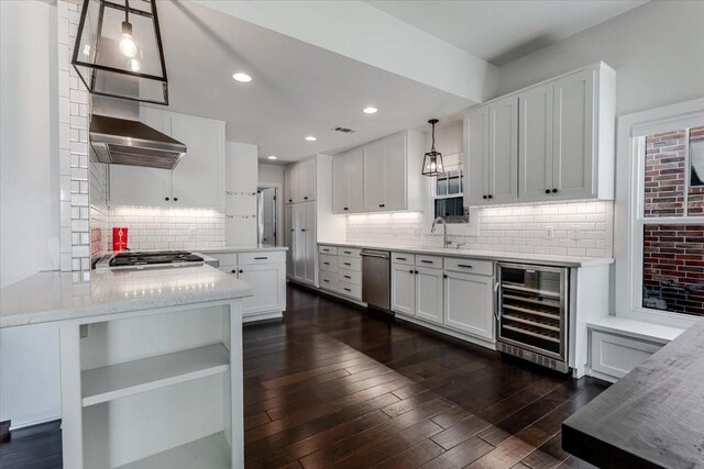 3813 Mattison Ave, Fort Worth, TX 76107 - kitchen featuring beverage cooler, stainless steel appliances, wall chimney range hood, decorative backsplash, and white cabinets