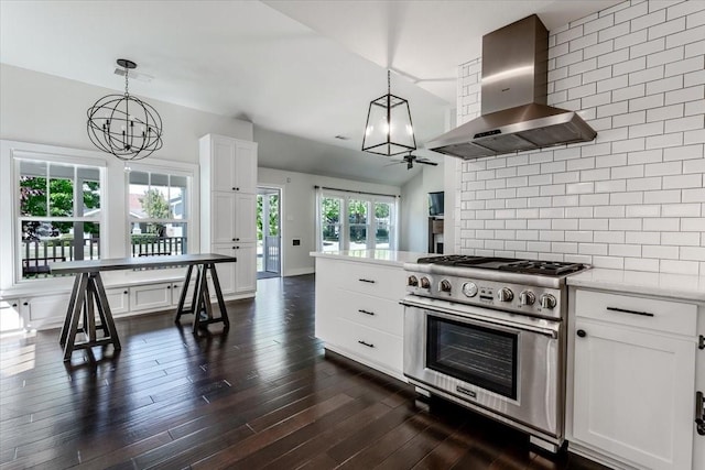 3813 Mattison Ave, Fort Worth, TX 76107 - kitchen featuring wall chimney range hood, stainless steel stove, a chandelier, decorative backsplash, and white cabinets