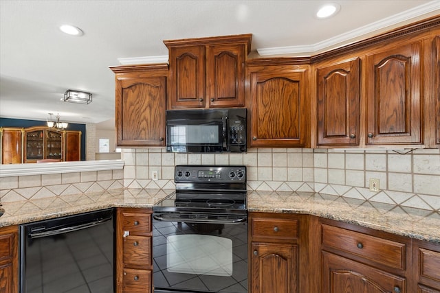 kitchen featuring tasteful backsplash, an inviting chandelier, crown molding, light stone countertops, and black appliances