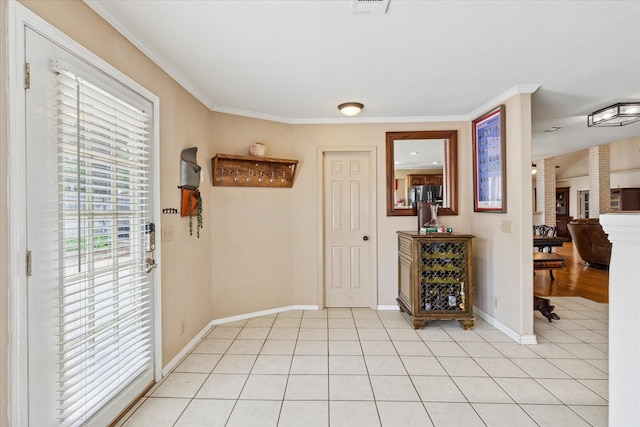 interior space with crown molding, baseboards, ornate columns, and light tile patterned flooring