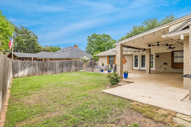 view of yard with a fenced backyard, a patio area, and a ceiling fan