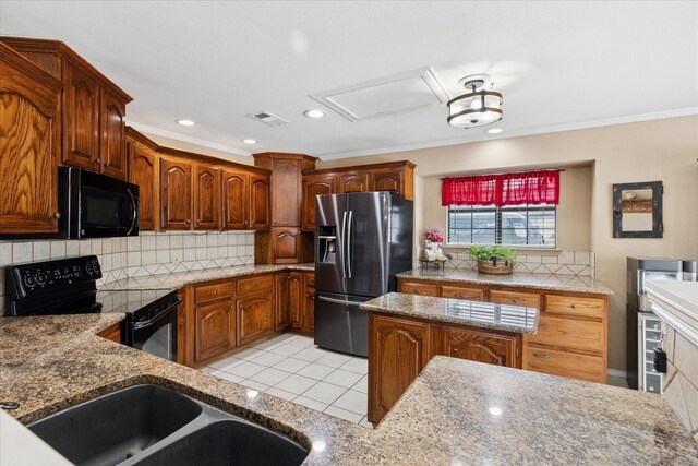kitchen with black appliances, tasteful backsplash, light stone counters, and visible vents