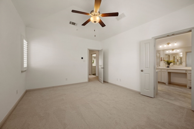 unfurnished bedroom featuring visible vents, baseboards, light carpet, and ensuite bathroom
