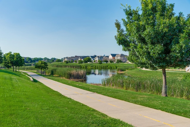 surrounding community featuring a lawn and a water view