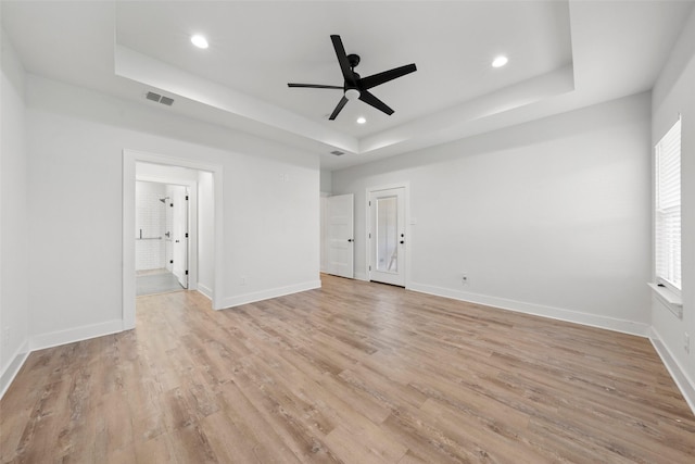 unfurnished bedroom with recessed lighting, light wood finished floors, a raised ceiling, visible vents, and baseboards