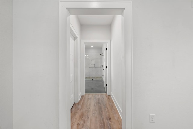 hallway with baseboards and light wood finished floors