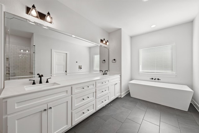 bathroom with a freestanding tub, a sink, a shower stall, and double vanity