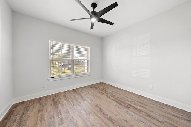 spare room featuring baseboards, a ceiling fan, and wood finished floors