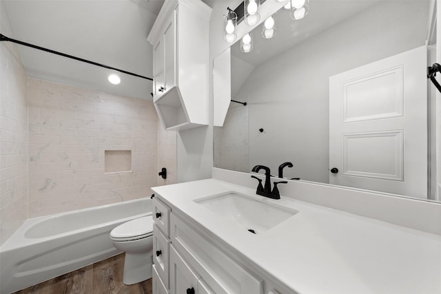 bathroom featuring wood finished floors, toilet, vanity, and  shower combination