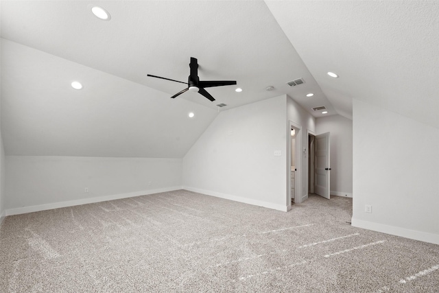 additional living space featuring vaulted ceiling, a ceiling fan, light colored carpet, visible vents, and recessed lighting