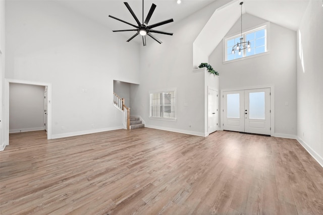 entrance foyer with baseboards, stairs, high vaulted ceiling, and a wealth of natural light