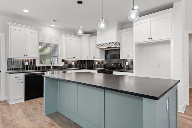 kitchen featuring dark countertops, a center island, black appliances, custom range hood, and white cabinets