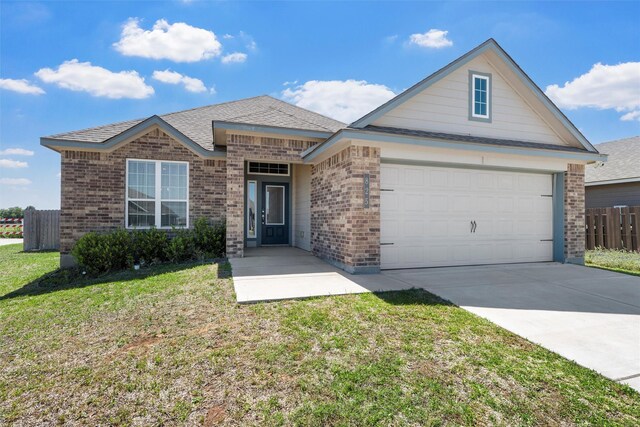 view of front facade with fence, brick siding, a front yard, and concrete driveway