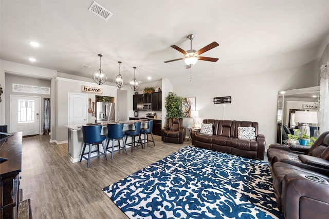 living area with a ceiling fan, visible vents, recessed lighting, and light wood-style flooring