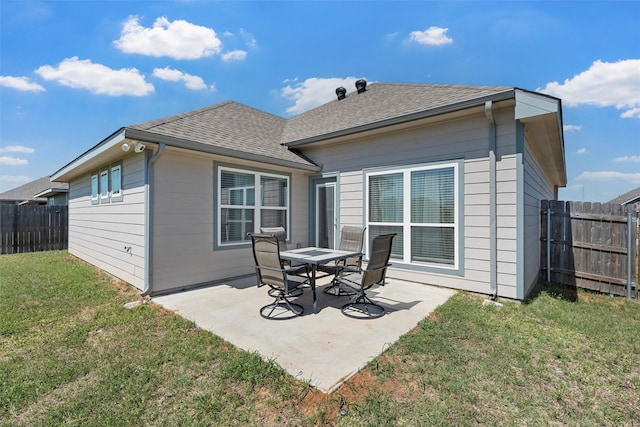 back of house with a patio area, a lawn, a fenced backyard, and roof with shingles